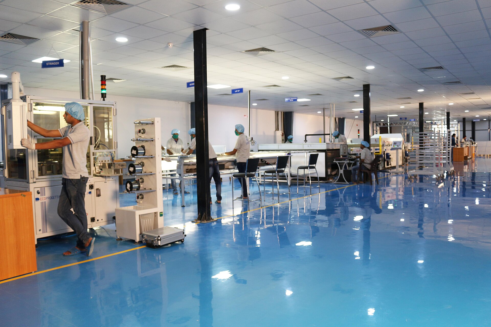 Workers assembling solar photovoltaic modules on a clean manufacturing floor